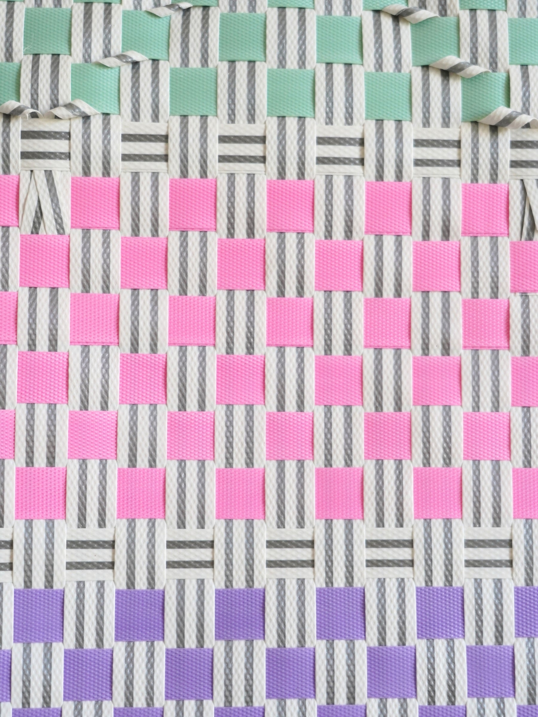 Gros plan du tressage coloré du panier Bubblegum, mélange de nuances vives, fait à la main au Vietnam.