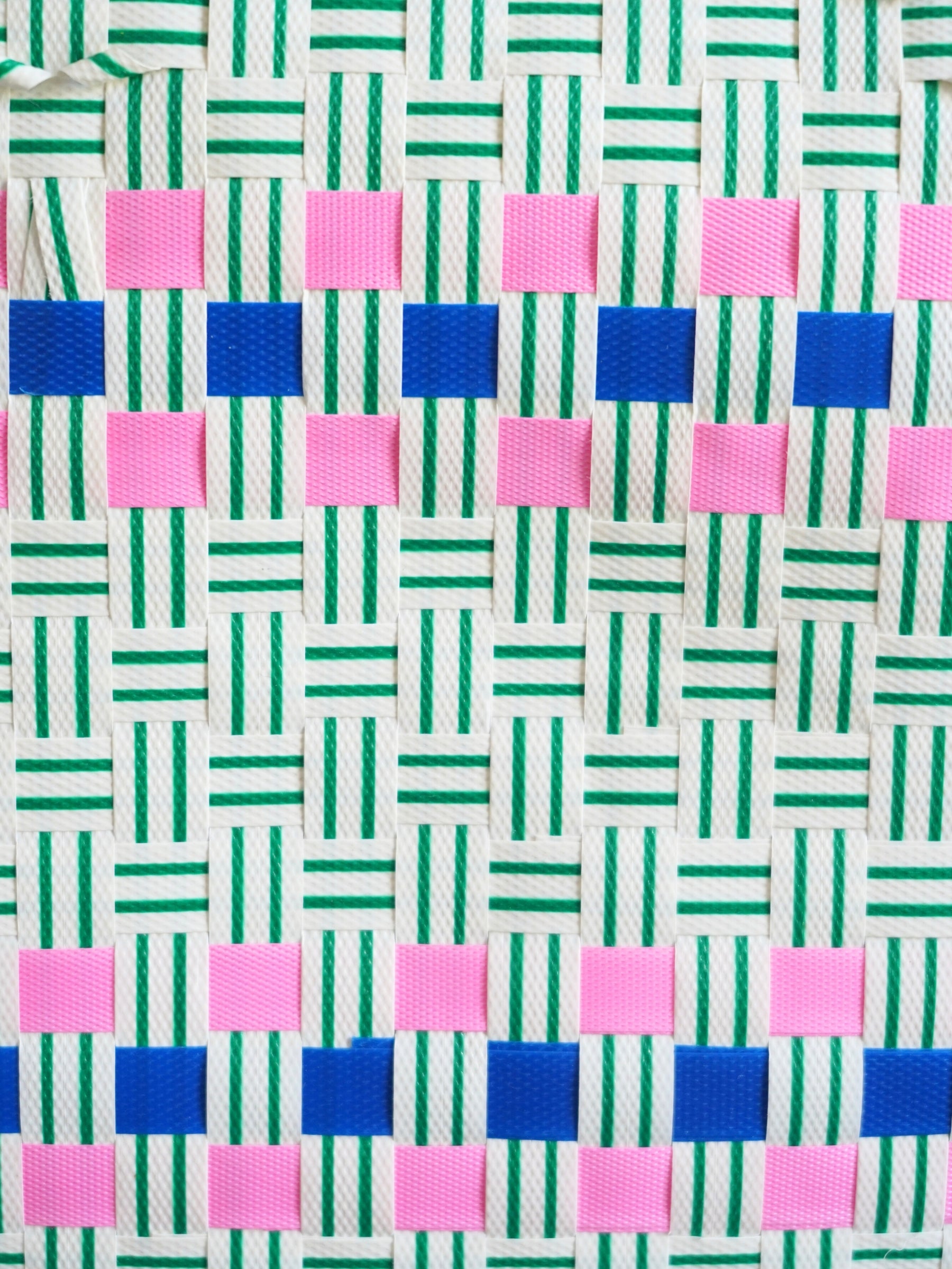 Gros plan sur le motif tressé du panier Lime, nuances vertes et bleues, fait à la main au Vietnam.
