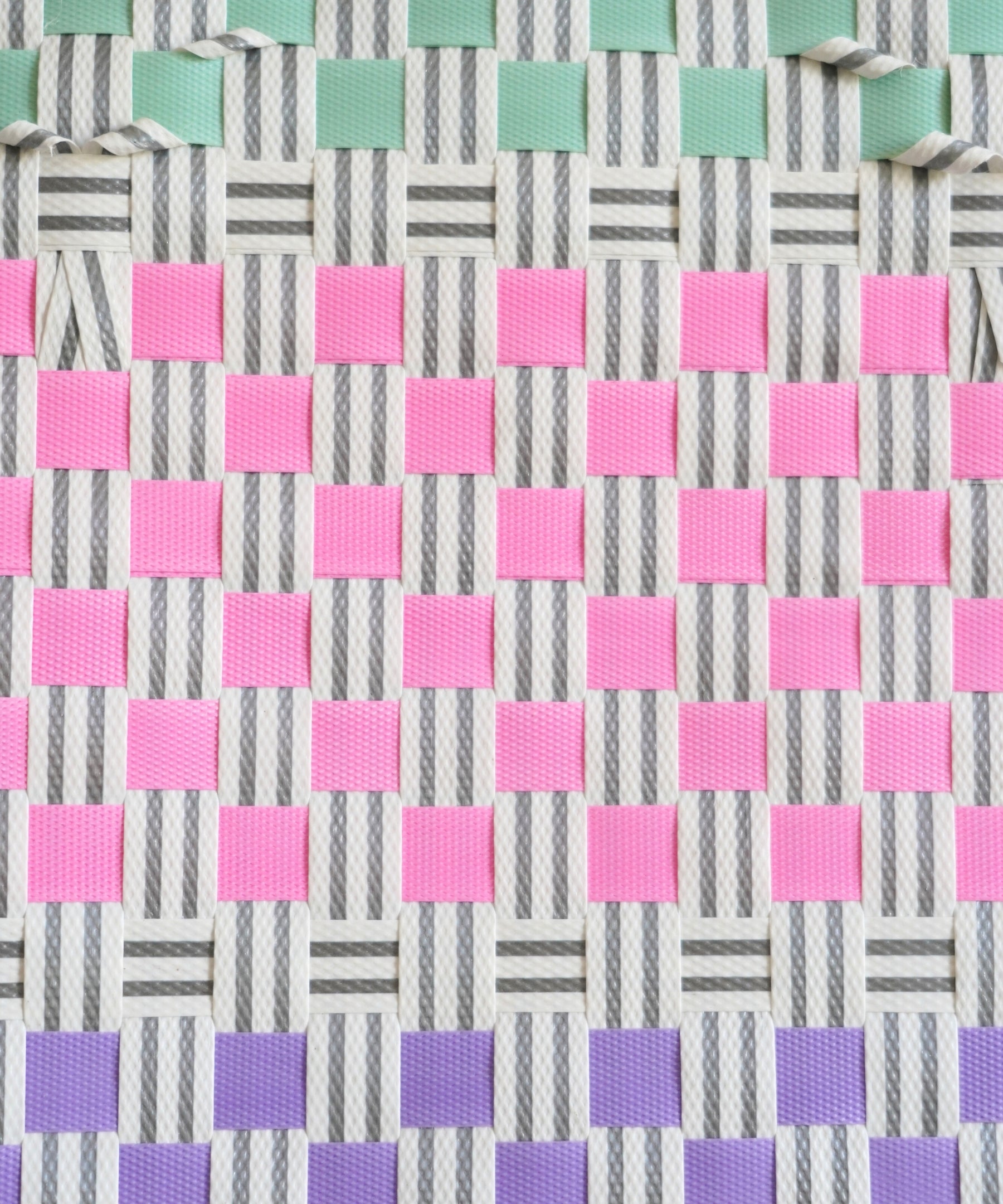 Gros plan du tressage coloré du panier Bubblegum, mélange de nuances vives, fait à la main au Vietnam.