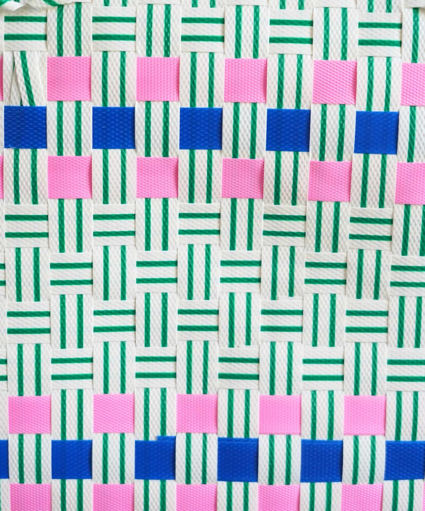 Gros plan sur le motif tressé du panier Lime, nuances vertes et bleues, fait à la main au Vietnam.